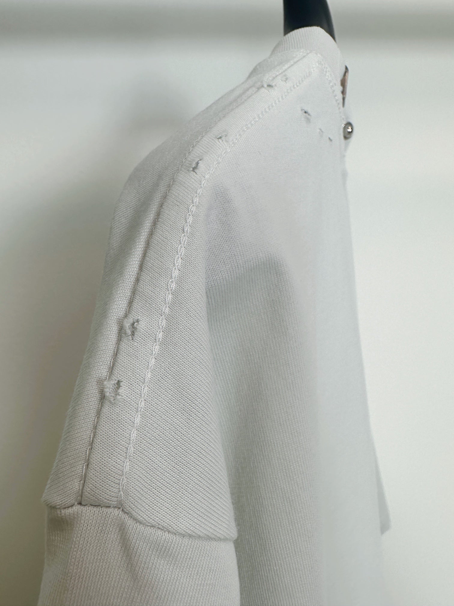 Balenciaga white short-sleeve T-shirt side view with distressed seam detail