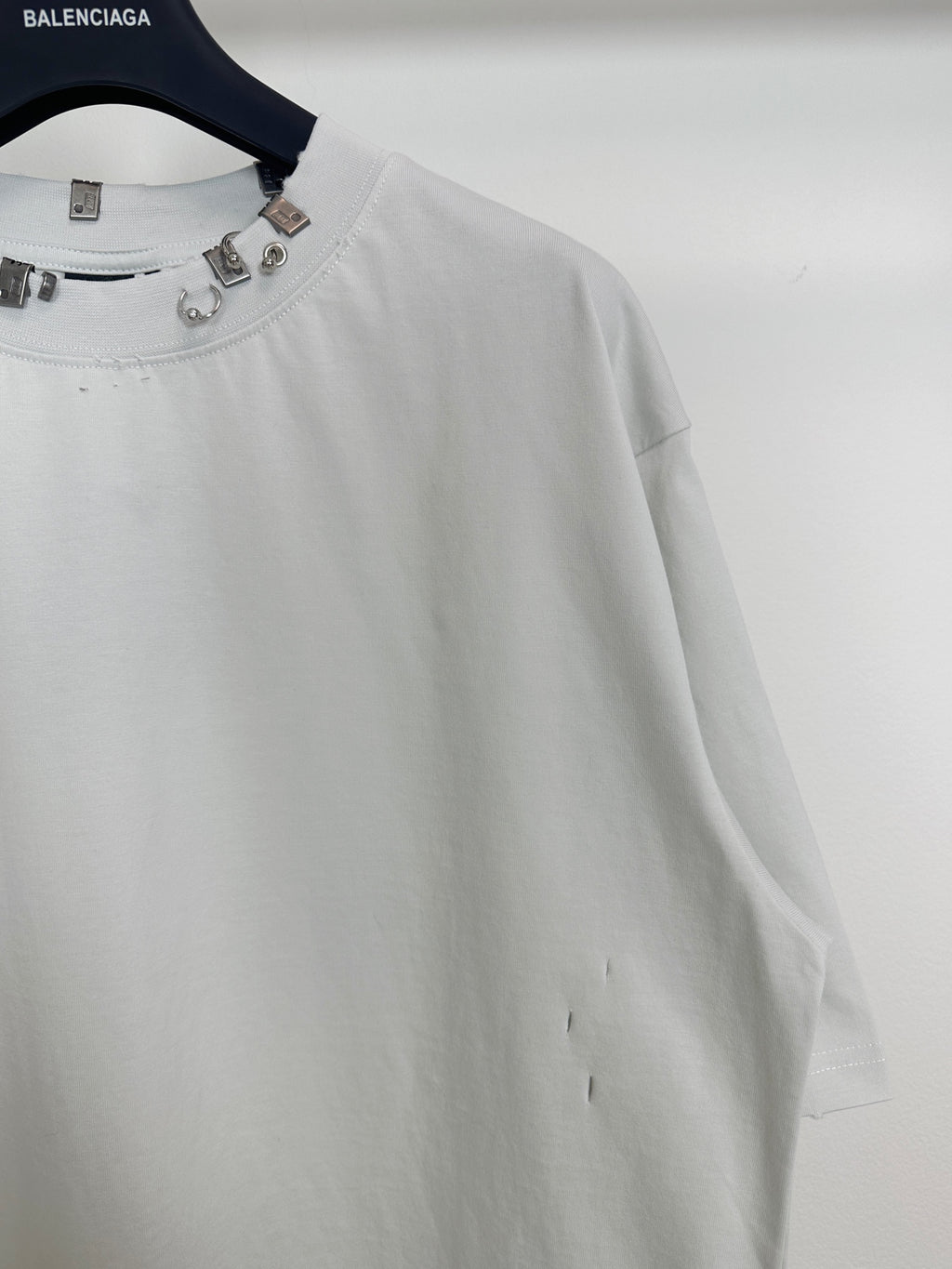 Balenciaga white short-sleeve T-shirt close-up of studded neckline and sleeve
