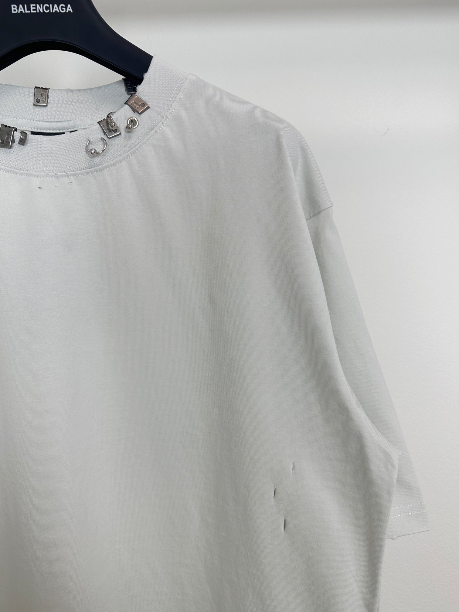 Balenciaga white short-sleeve T-shirt close-up of studded neckline and sleeve