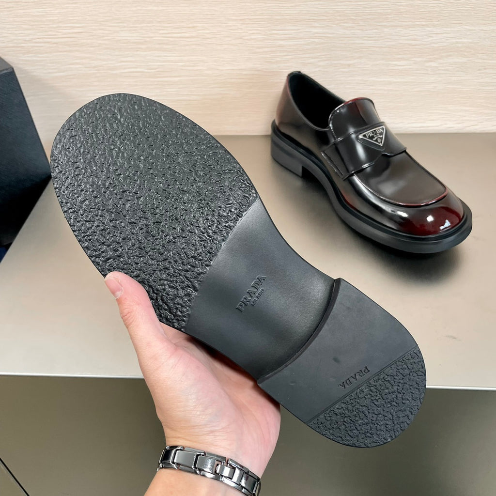 Prada unisex loafer outsole shown, black textured sole with brand mark