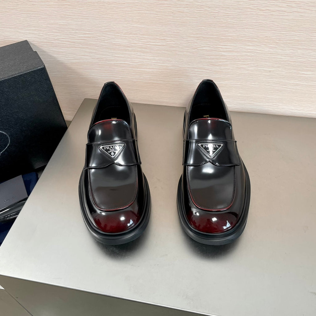 Prada unisex loafers, black leather slip-on with gloss burgundy toe and logo hardware