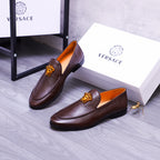 Pair of brown leather slip-on loafers with gold Medusa emblems