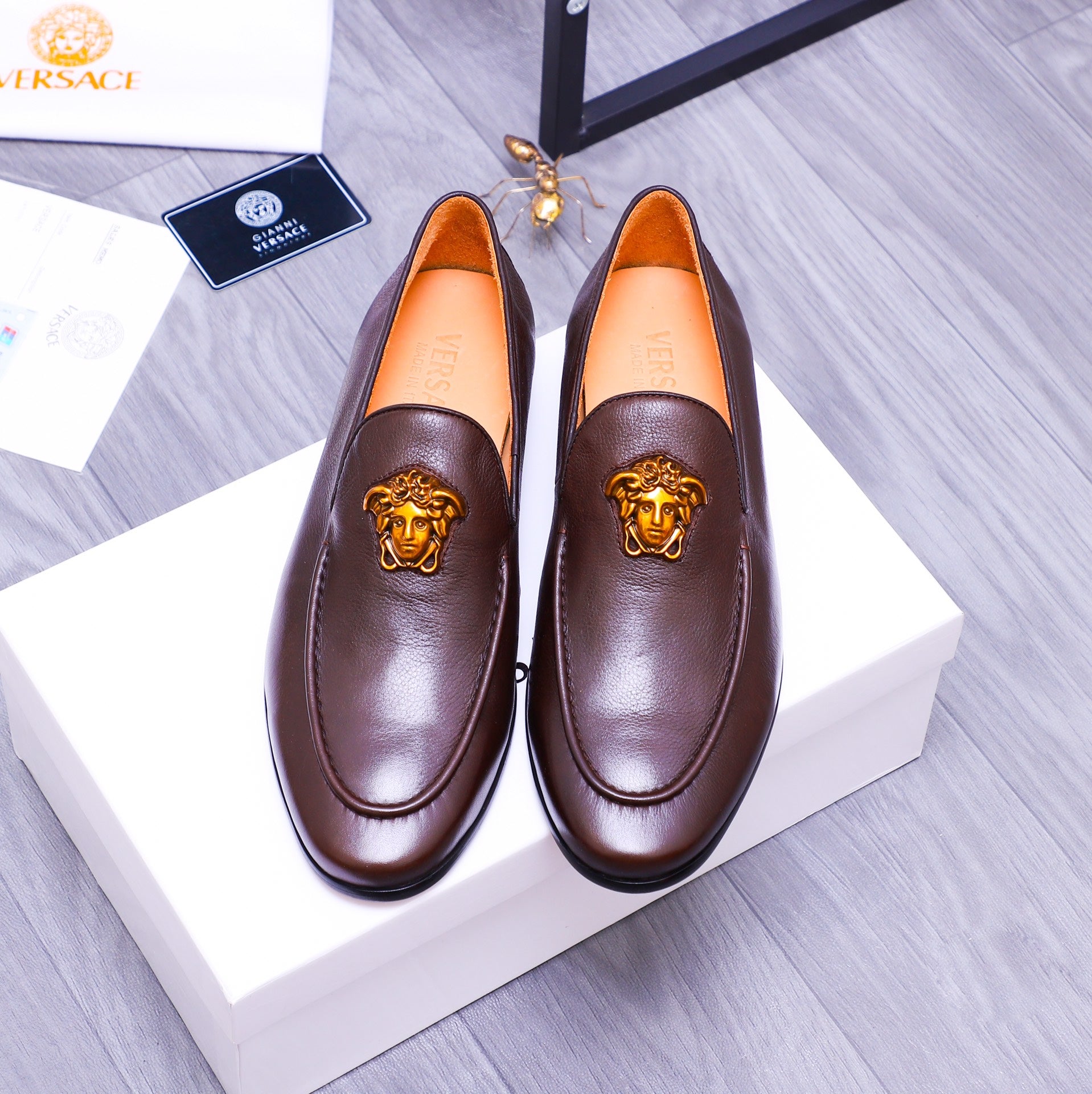 Brown leather slip-on loafers with gold Medusa emblem