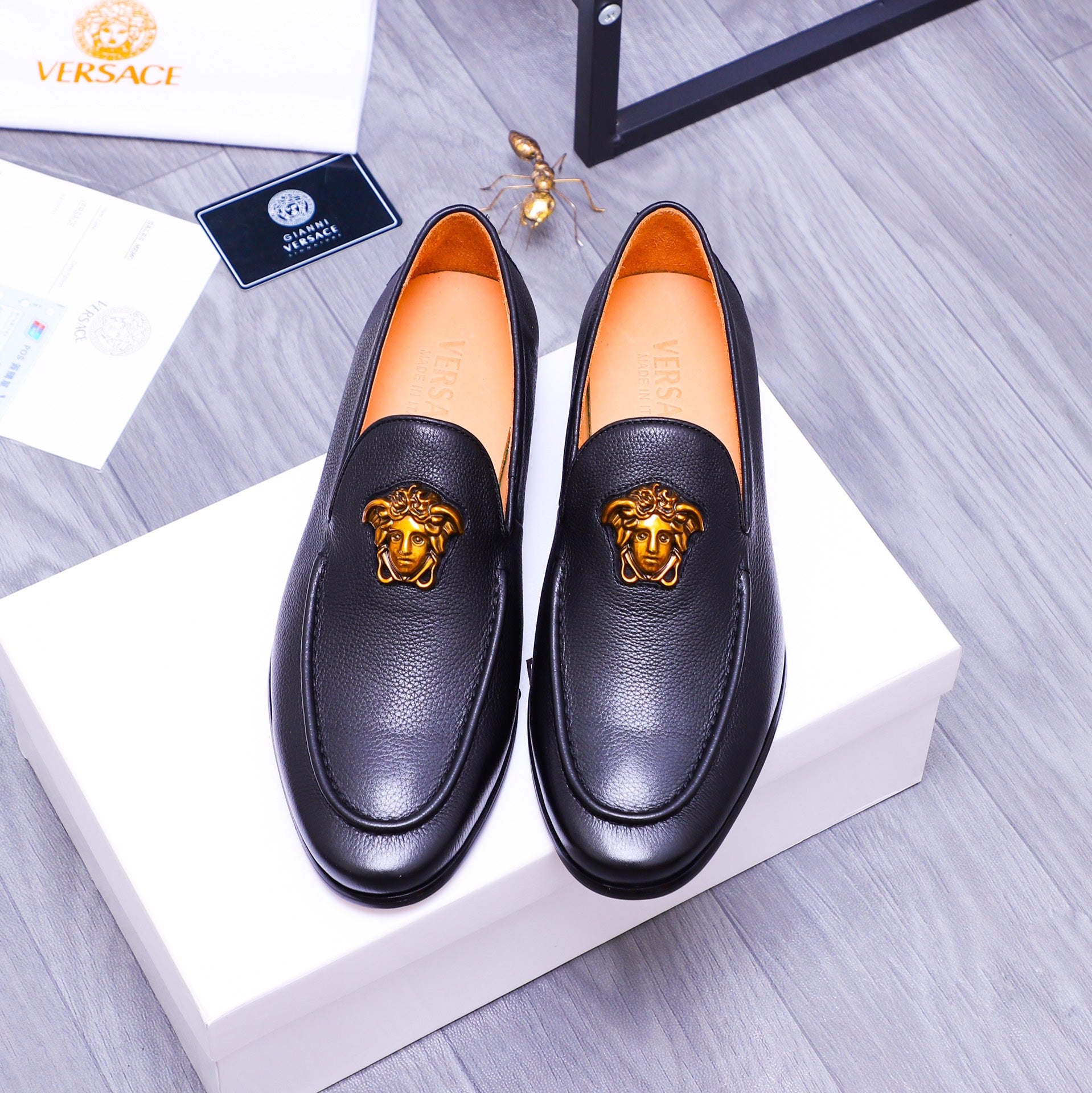 Versace black leather loafers with gold Medusa emblem and orange interior lining