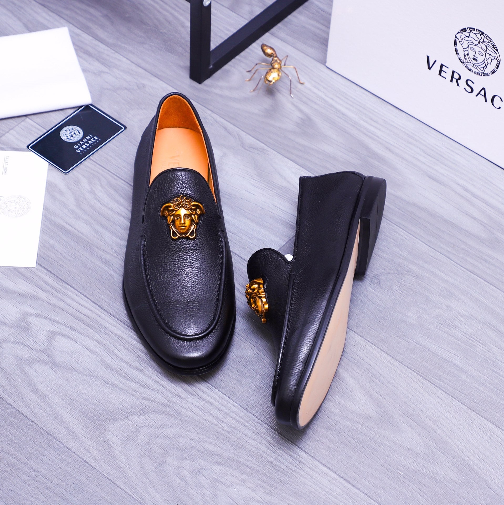 Versace black leather loafers with gold Medusa emblem and orange interior lining