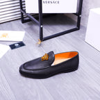 Versace black leather slip-on loafers with gold Medusa detail and orange lining