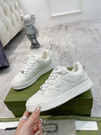 White Gucci unisex lace-up sneakers with logo detail on the strap and perforated panels.