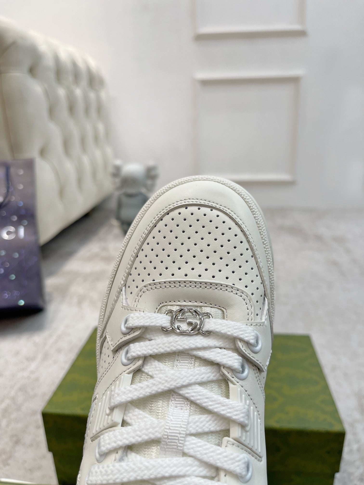 Gucci unisex luxury sneakers, white front view with lace-up and signature ring detail