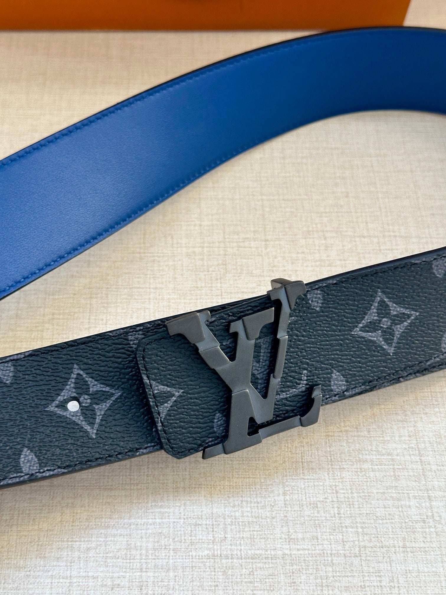 Louis Vuitton monogram belt close-up of dark blue strap and metal buckle