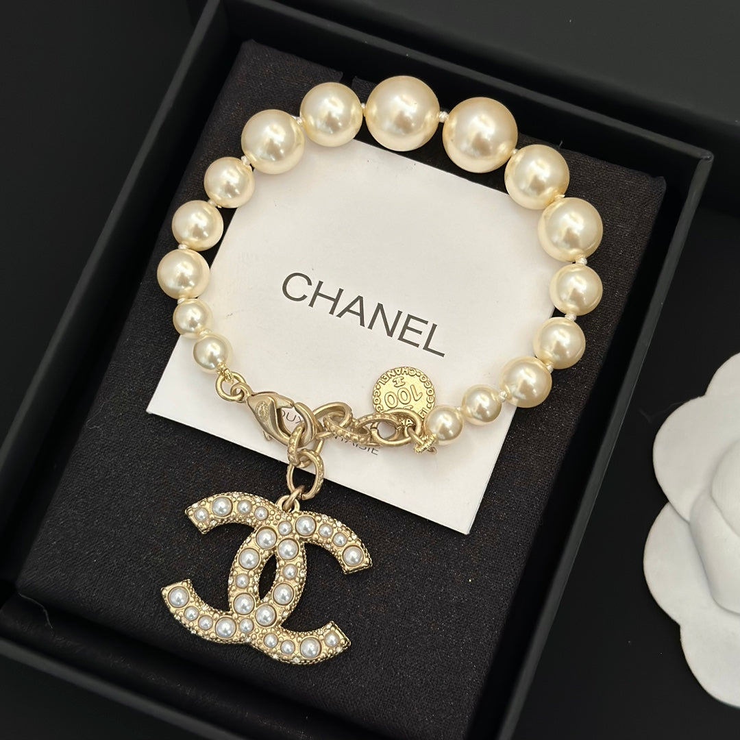 Chanel pearl bracelet with gold-tone chain and jeweled rocking-horse charm