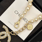 Chanel pearl bracelet with gold-tone chain, logo medallion, and dangling charm