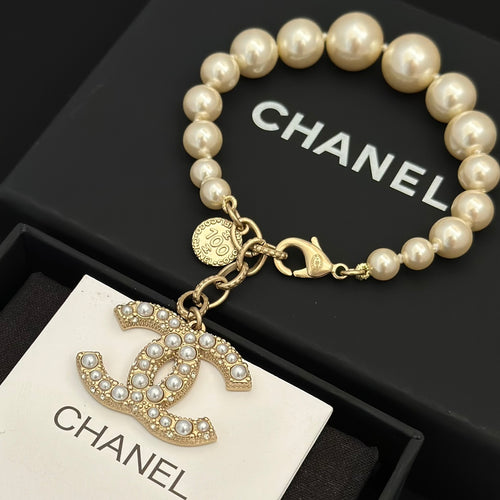 Chanel pearl bracelet with gold-tone chain and rhinestone CC logo charm
