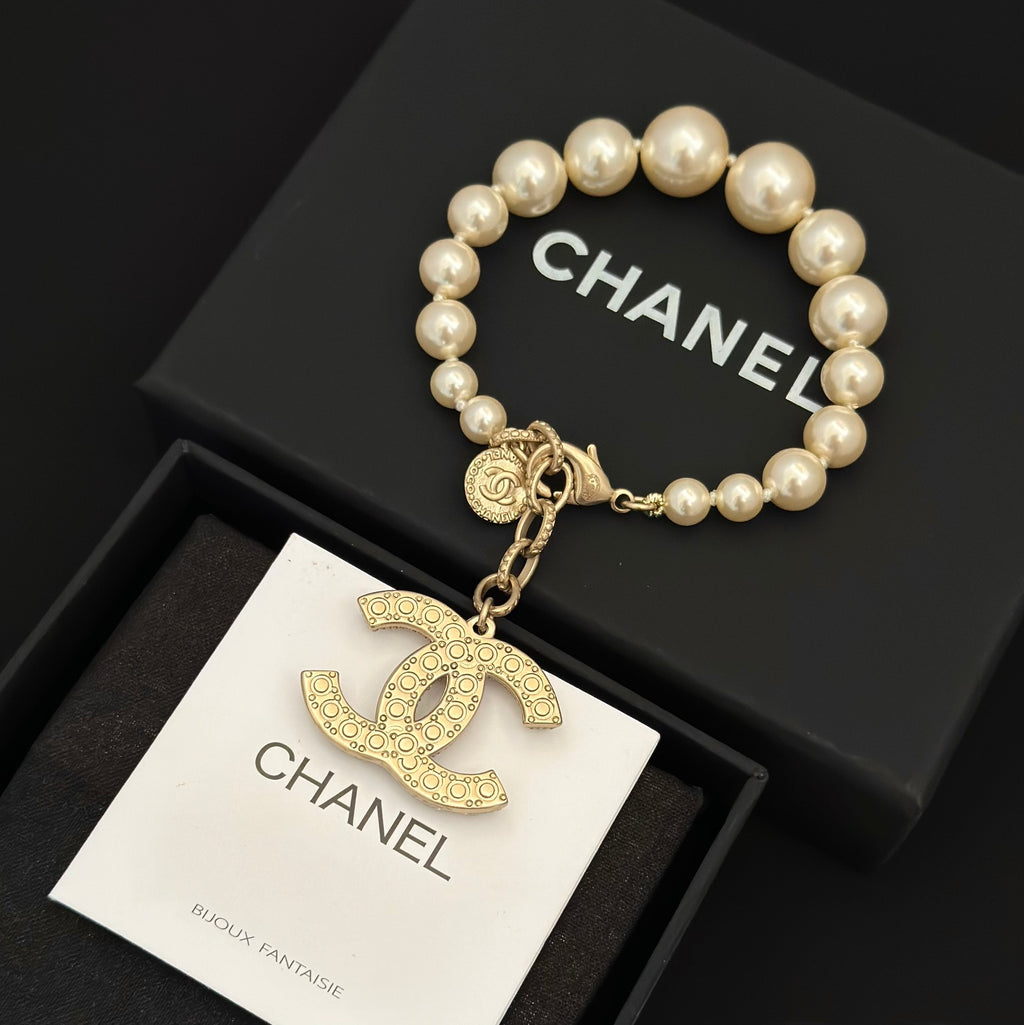 Chanel pearl bracelet with gold-tone chain and jeweled rocking-horse charm