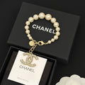 Chanel pearl bracelet with gold-tone chain and dangling logo charm