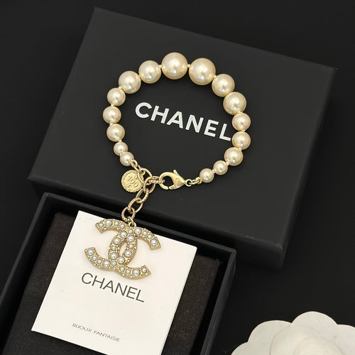 Chanel pearl bracelet with gold-tone chain and dangling logo charm