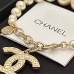 Chanel pearl bracelet close-up with gold-tone chain and logo charm medallion