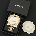 Chanel pearl bracelet with gold-tone chain and large rhinestone CC charm