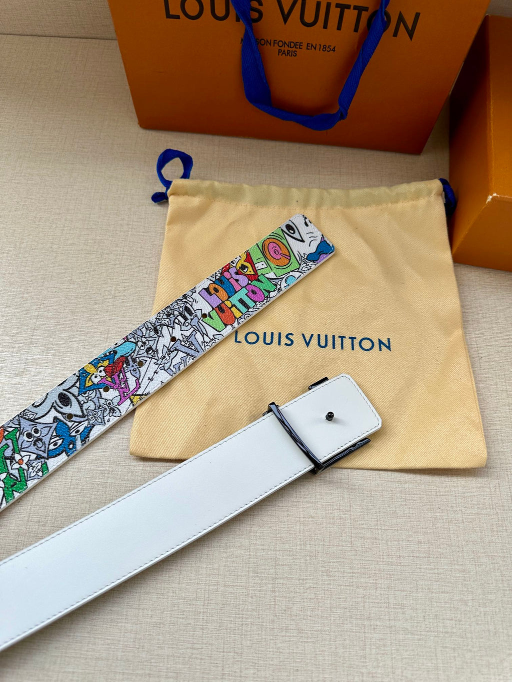 White leather belt with multicolor graffiti strap and buckle; matching pouch