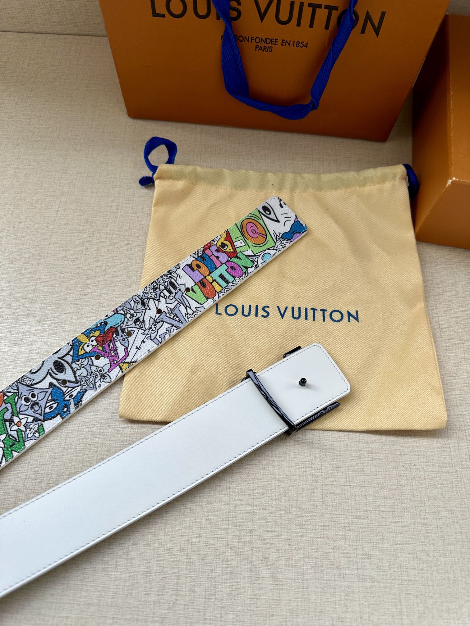 White leather belt with multicolor graffiti strap and buckle; matching pouch