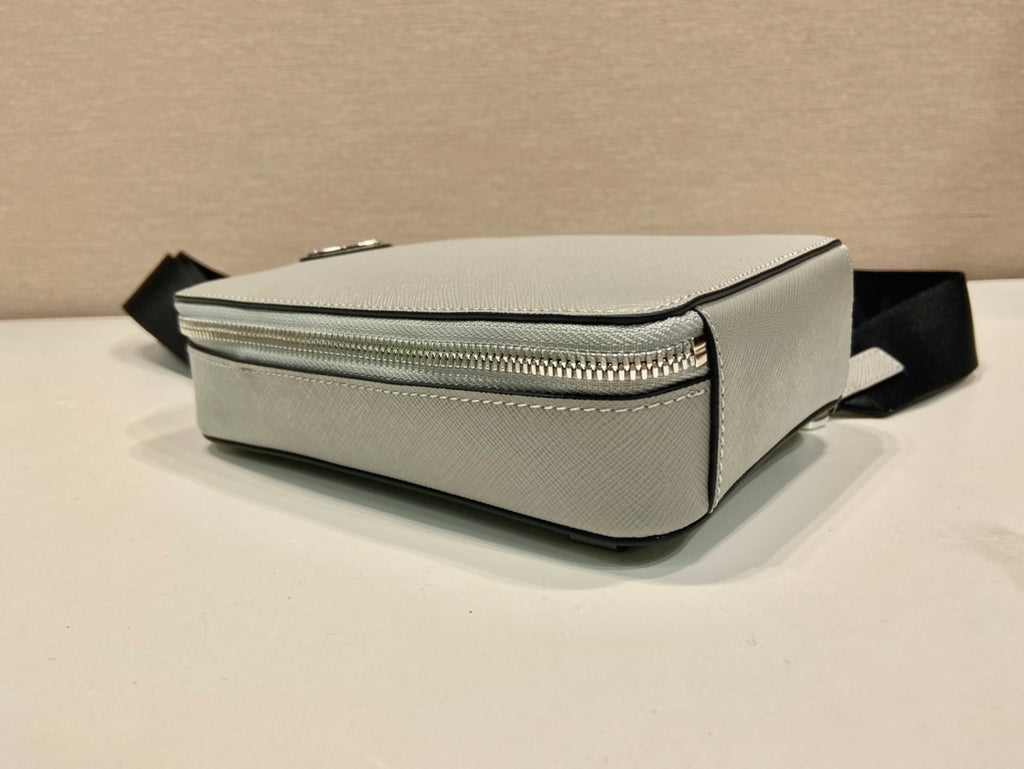 Prada mini bag, light gray side profile with silver zipper and black strap