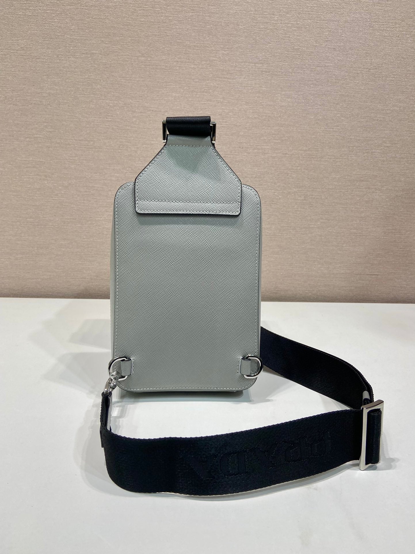 Prada mini crossbody bag, light gray back with top tab and adjustable black strap