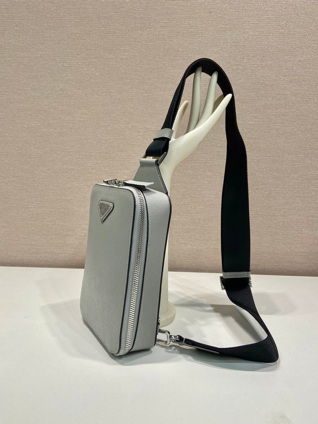 Prada mini crossbody bag, light gray with vertical zip pocket and black strap