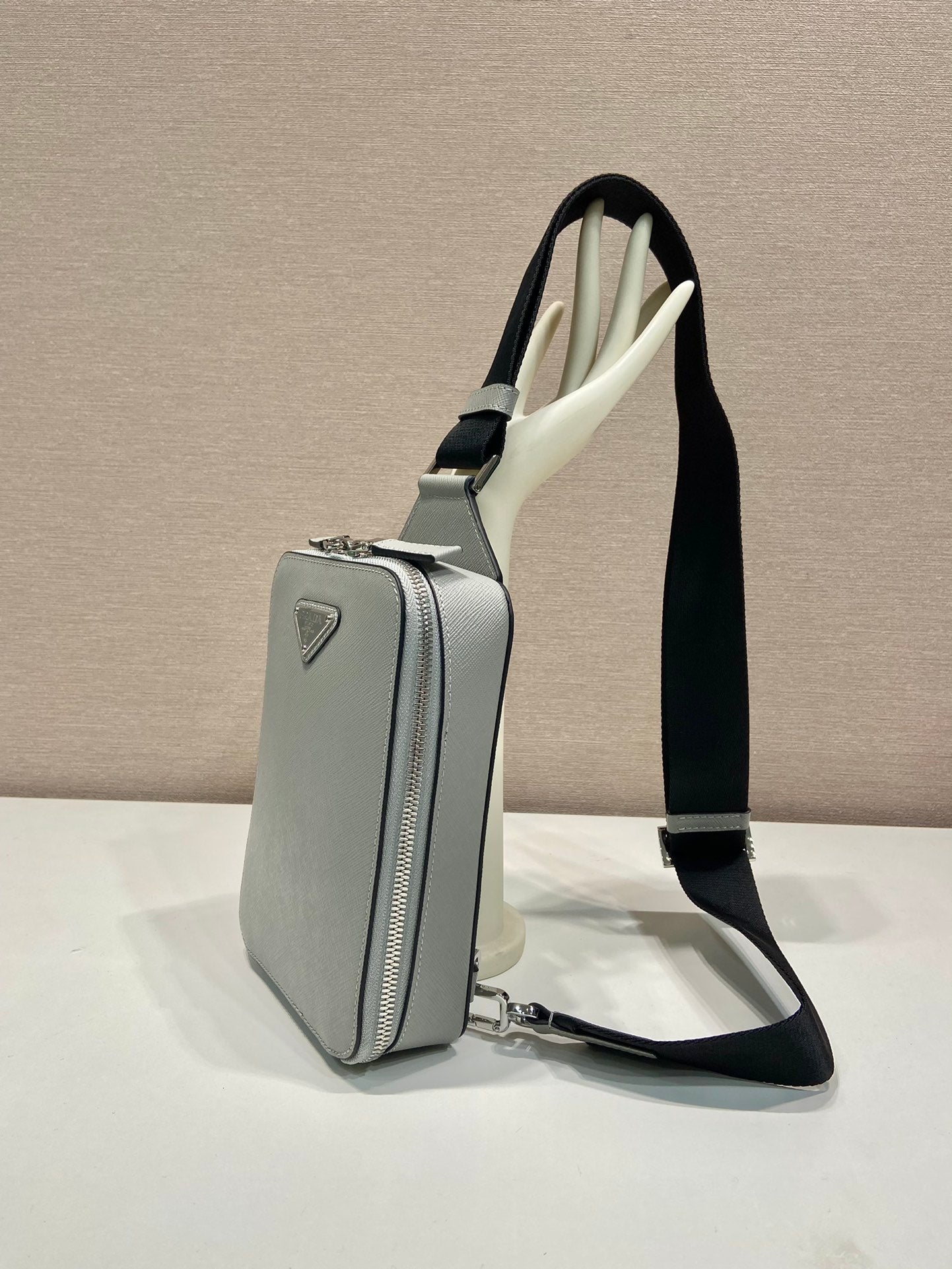 Prada mini crossbody bag, light gray with vertical zip pocket and black strap