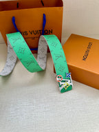 Louis Vuitton belt with green-and-white monogram straps and silver buckle with charms