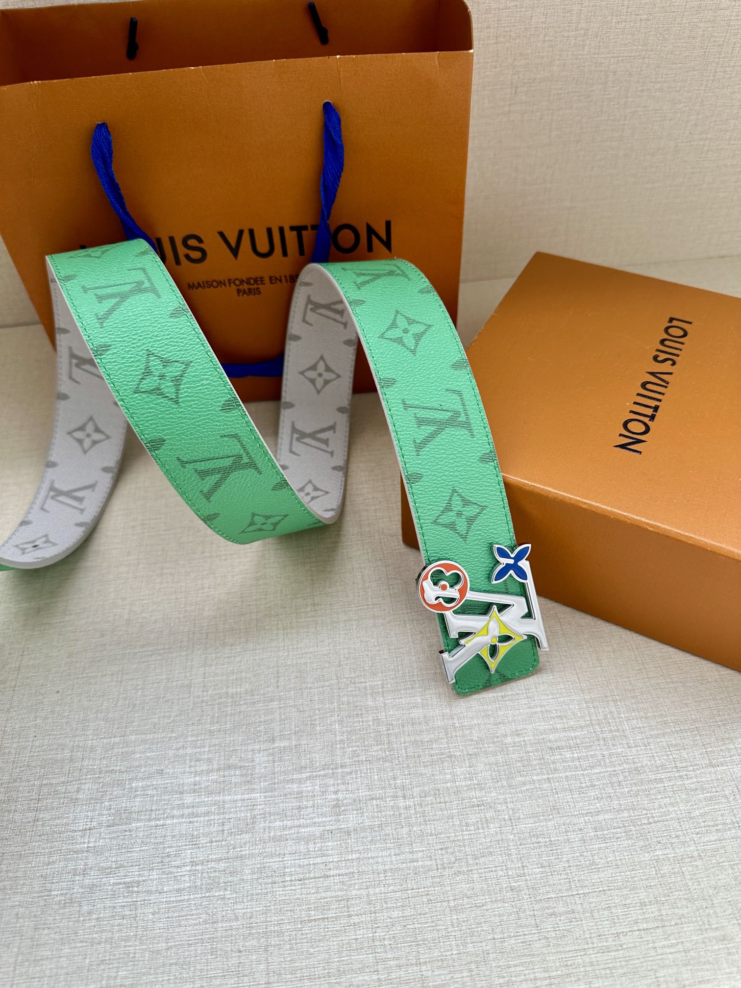 Louis Vuitton belt with green-and-white monogram straps and silver buckle with charms
