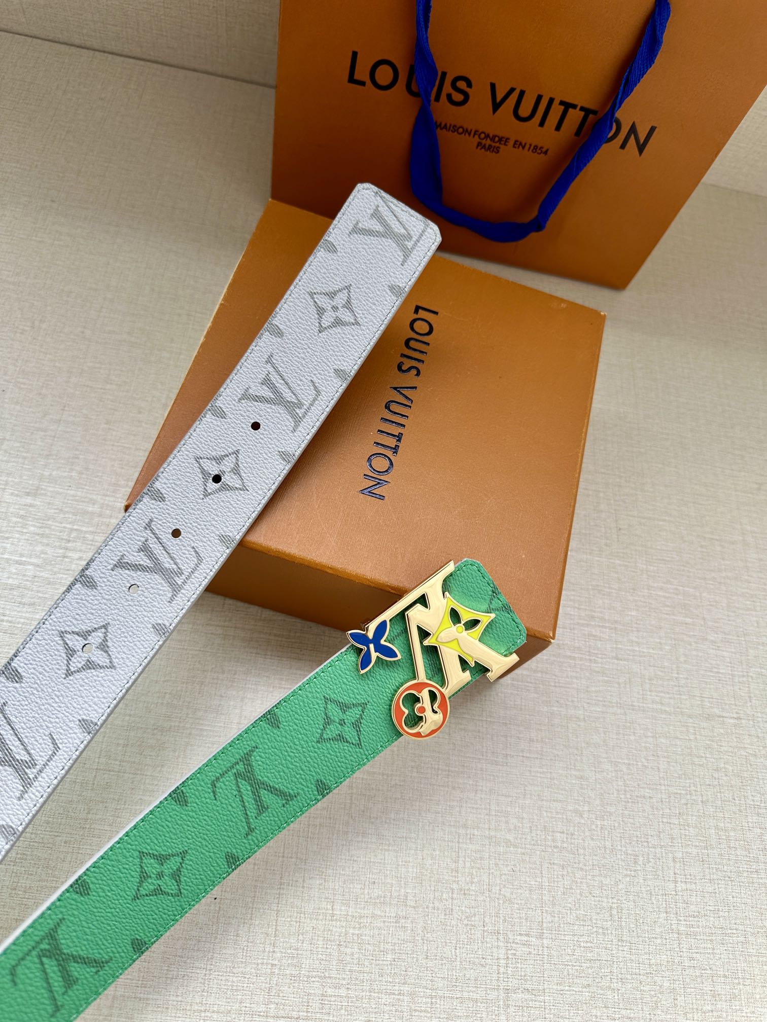 Louis Vuitton belt with green and gray monogram straps and silver buckle with charms