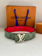 Louis Vuitton belt on display: green monogram strap with red underside and gold-tone LV buckle
