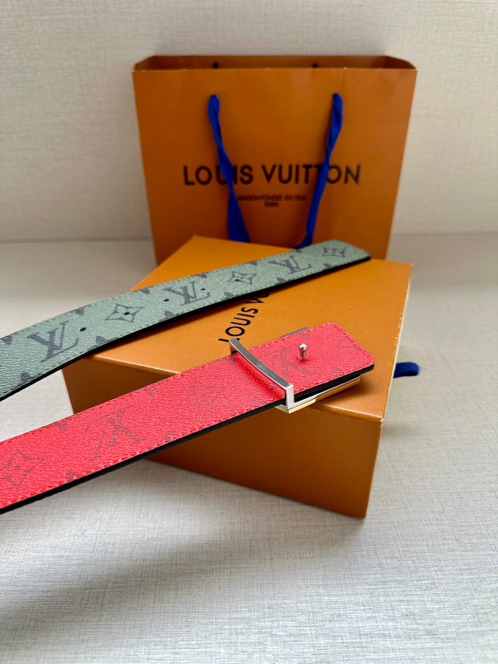 Louis Vuitton belt with green monogram strap and red underside, silver clasp buckle detail