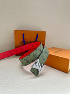 Louis Vuitton belt draped with green monogram strap, red underside strap, silver LV buckle