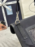 Prada bag hardware detail with metal rings and textured strap, dark leather front