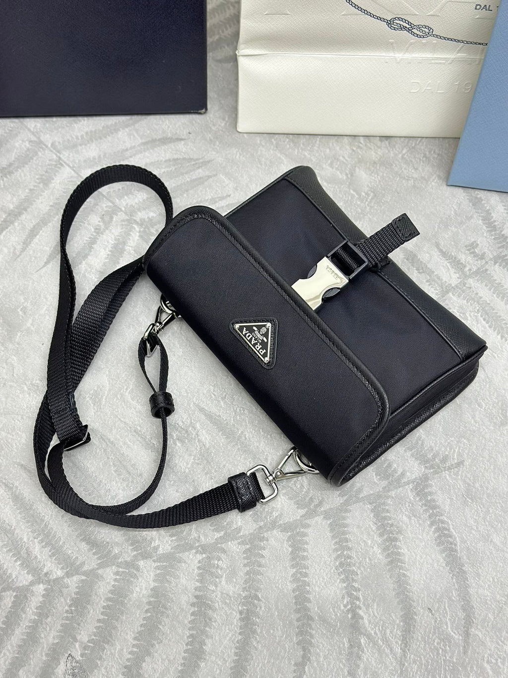 Prada crossbody bag with strap and front logo plaque, dark textured fabric and flap