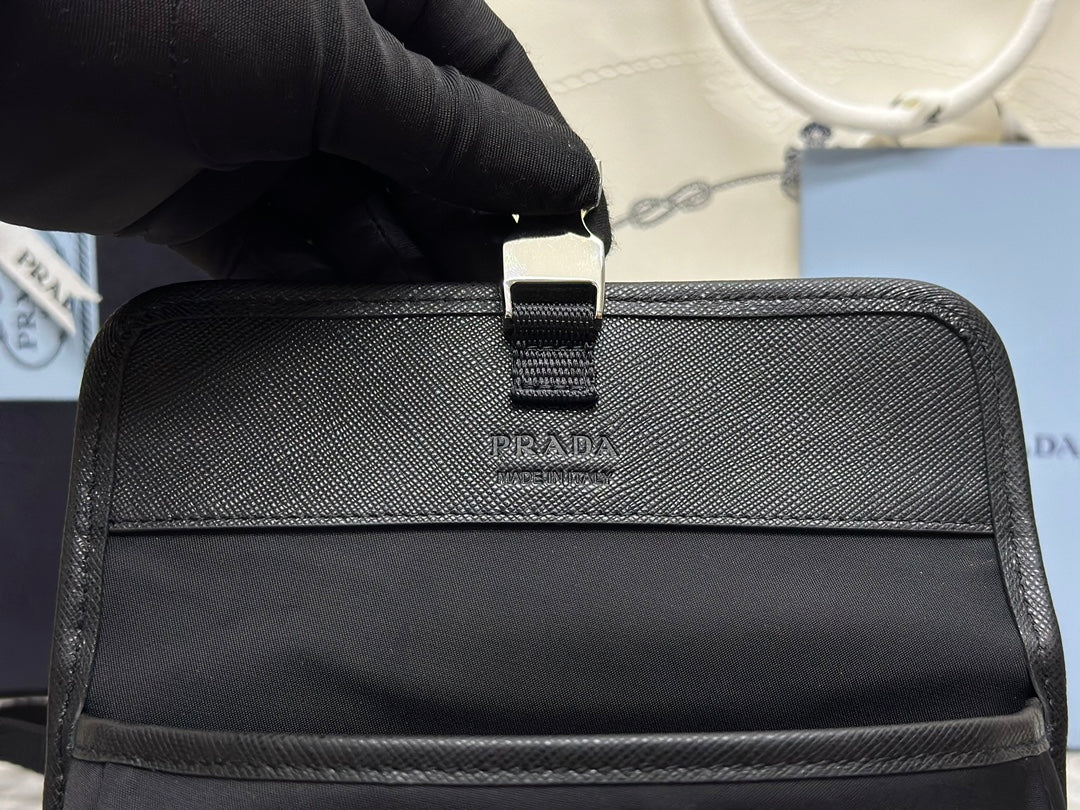 Prada bag front panel with small center logo tag and adjustable strap, dark finish