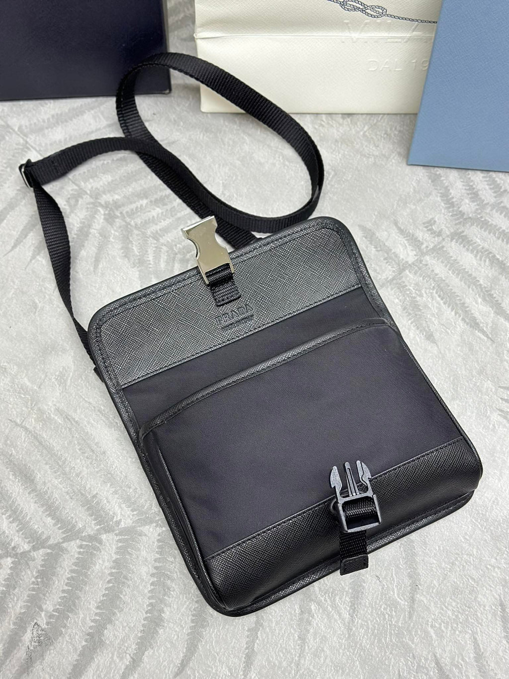 Prada bag with adjustable crossbody strap and front flap pocket, dark leather exterior