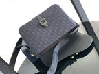 Dark crossbody bag with patterned top flap and adjustable shoulder strap