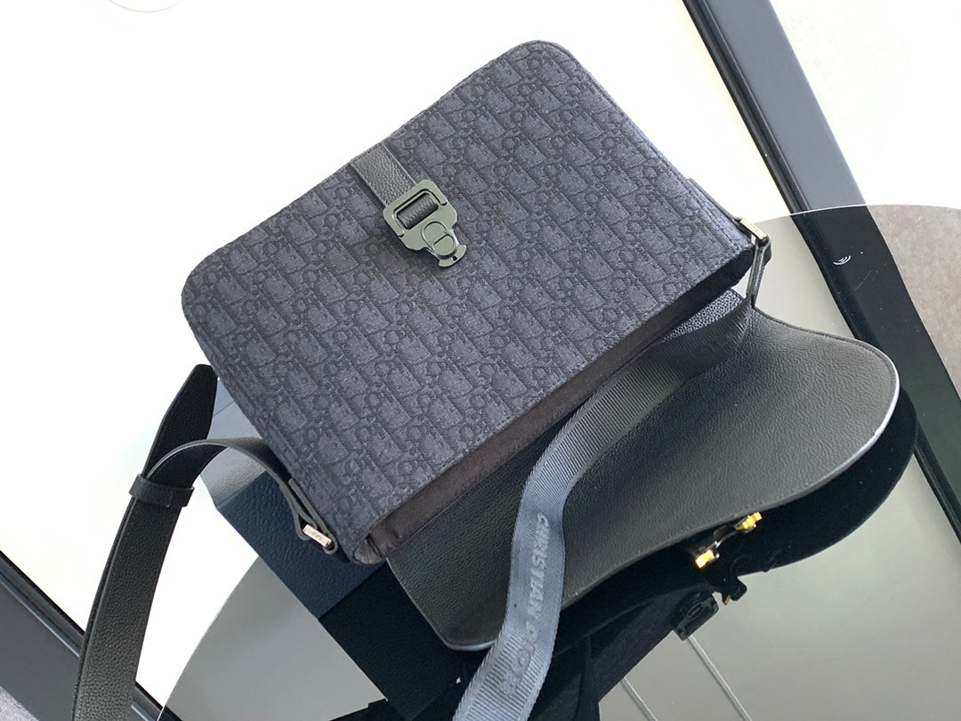 Dark crossbody bag with patterned top flap and adjustable shoulder strap