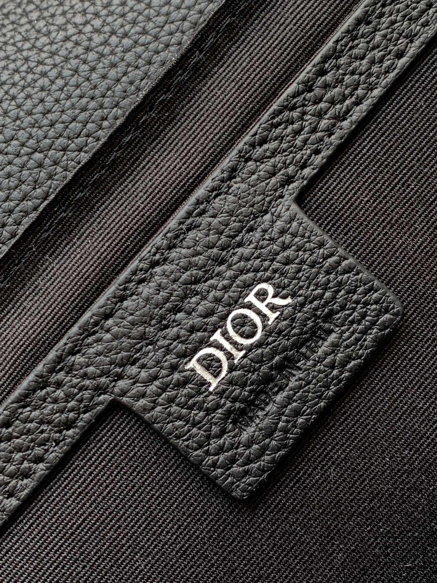 Dark leather bag patch with Dior logo stitching detail