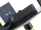Dark crossbody bag with long front flap and textured pattern, secured with hardware