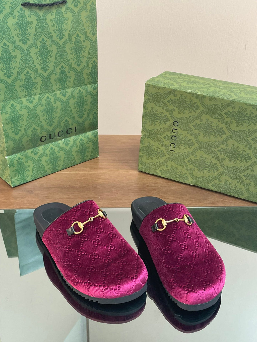 Pair of pink velvet slide sandals with gold horsebit, side view