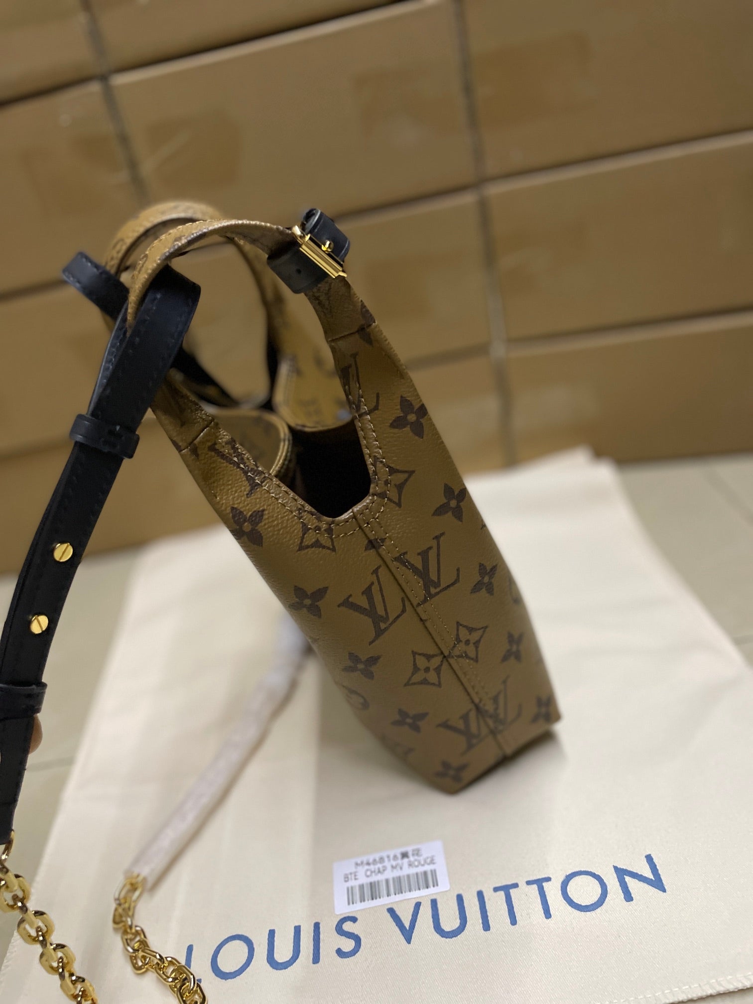 Louis Vuitton monogram hobo bag with navy shoulder strap and gold zipper pulls