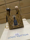 Louis Vuitton monogram handbag with tan canvas and navy leather straps, gold hardware