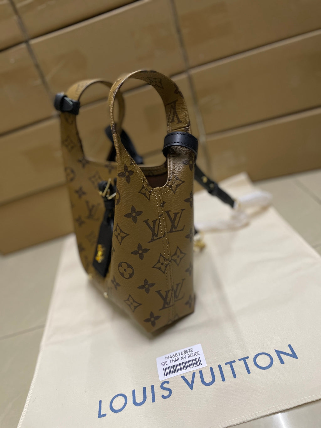 Louis Vuitton monogram handbag with navy top straps and adjustable buckle hardware