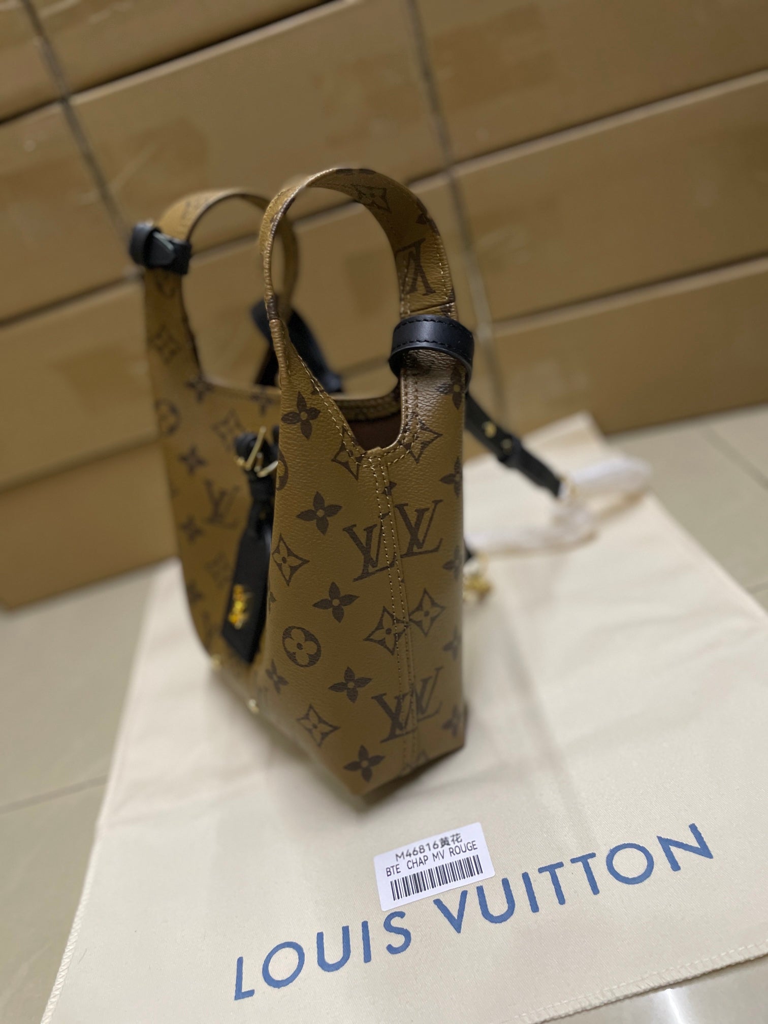 Louis Vuitton monogram handbag with navy top straps and adjustable buckle hardware