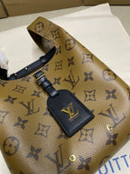 Louis Vuitton monogram handbag with navy front leather patch and gold emblem hardware