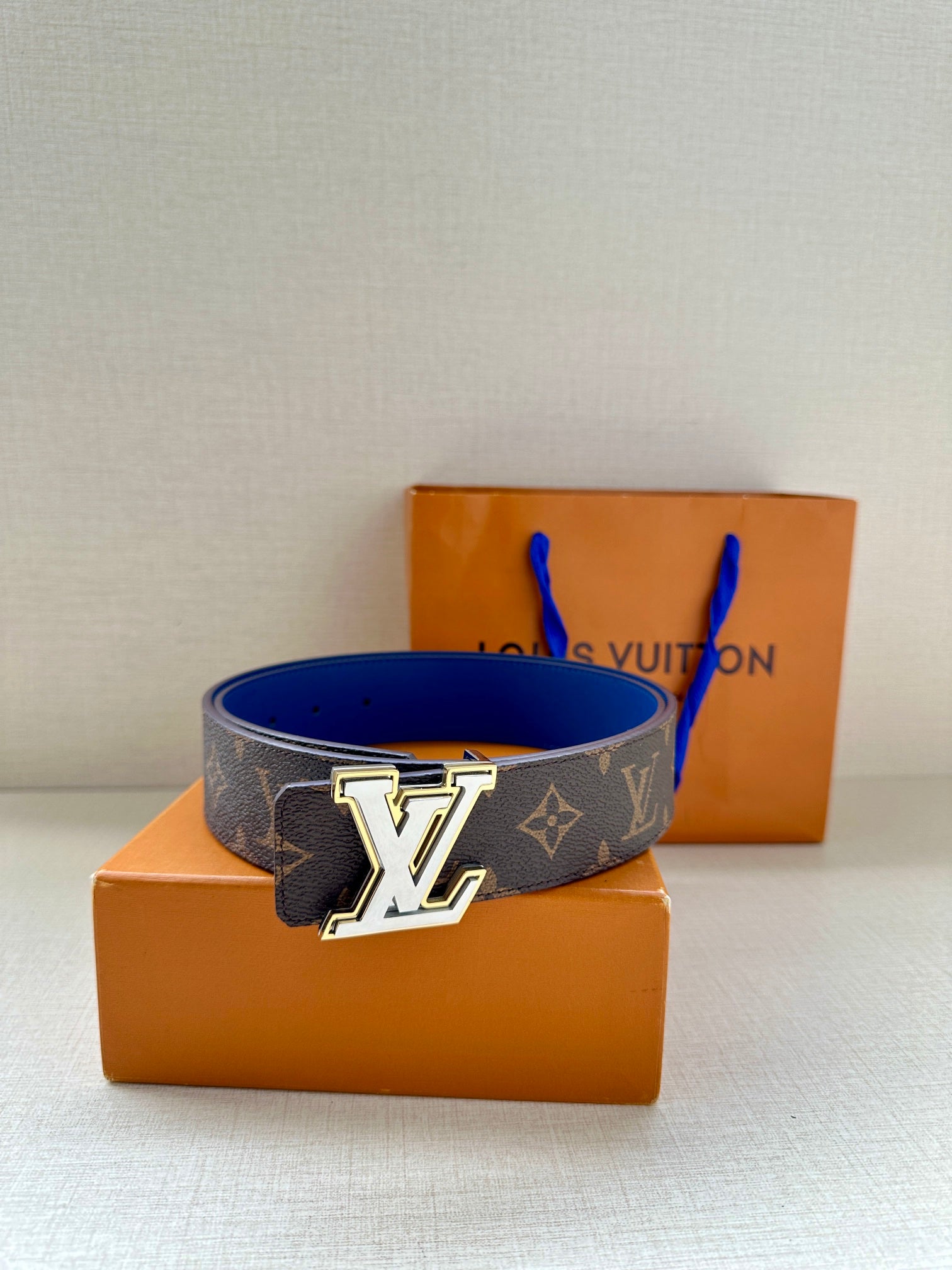 Louis Vuitton monogram belt featuring dark canvas band and blue leather strap, LV buckle