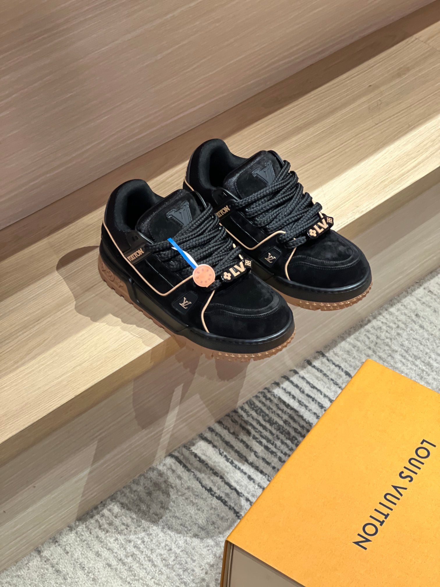 Louis Vuitton trainer shoes, black with gold trim and blue details, side-by-side view
