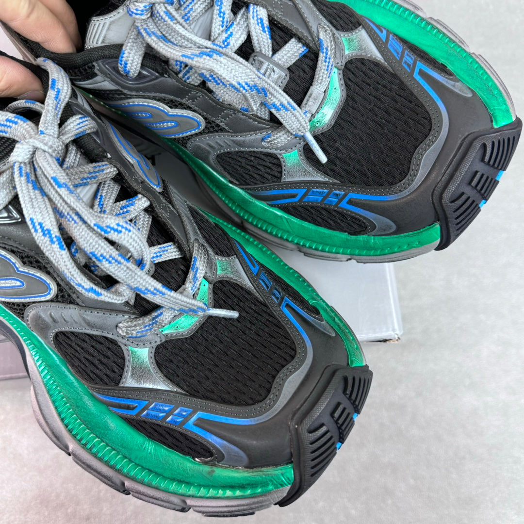 Unisex sneaker instep close-up, black mesh, gray overlays, blue stripes, green midsole edge.